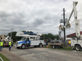 A group of contractors fixing an electrical pole